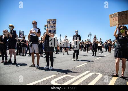 Brighton, Großbritannien. Juni 2020. Während eines BLM-Protestes entlang der Küste in Brighton stehen Menschen auf der Straße.Lokale Aktivisten in England organisierten einen Protest im Zentrum von Brighton, um den systemischen Rassismus und die Polizeibrutalität in Großbritannien zu unterstreichen. Kredit: SOPA Images Limited/Alamy Live Nachrichten Stockfoto