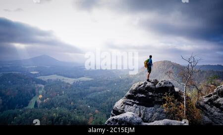 Mann Reisende mit Rucksack ist Bergsteigen. Reisezielort Urlaubskonzept. Entspannen Sie sich auf einem Berg mit schöner Aussicht Stockfoto