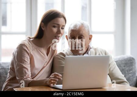 Fürsorgliche Erwachsene Tochter Lehre älteren Vater zu verwenden Laptop Stockfoto