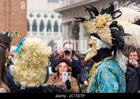 Venedig, Italien - 30. Januar 2016: Piazza San Marco oder Markusplatz in Venedig - schöne Masken posieren mit Touristen Stockfoto