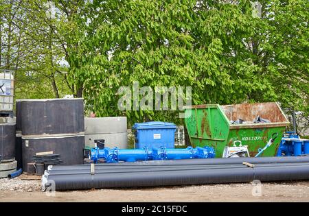 Rohre, vorgegossene Stahlbeton Brunnenringe, Müllhalde und andere Dinge auf der Baustelle Stockfoto