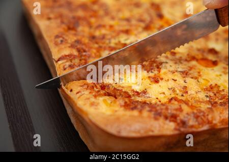 Nahaufnahme von Frauen Hand schneiden Brazilian Blender Bohnenkuchen - traditionelle brasilianische Küche. Stockfoto