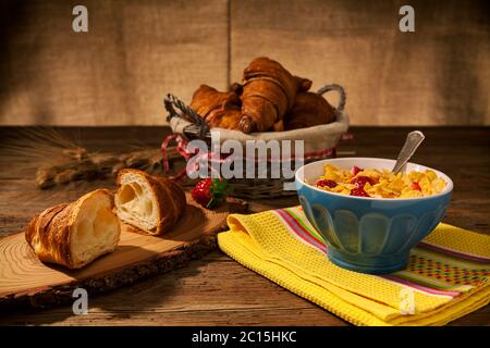 Kontinentales Frühstück mit Cornflakes und Erdbeeren in eine Schale Milch und Croissant Stockfoto