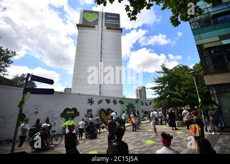 Menschen in der Grenfell Memorial Community Mosaik am Fuße des Tower Blocks in London zum dritten Jahrestag des Grenfell Tower Feuers, der am 14 2017. Juni 72 Menschenleben forderte. Stockfoto