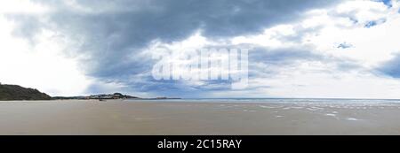 Panoramabild eines Strandes oder einer Bucht am atlantik mit Sand, Wellen und einem blauen Himmel mit schönen Wolken im Sommer an einem sonnigen Tag im Sommer Stockfoto