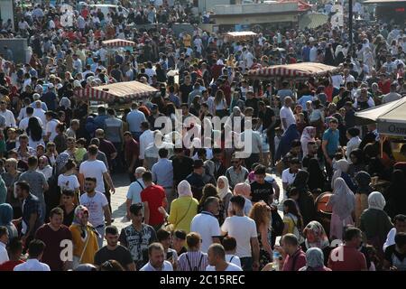 EMINONU, ISTANBUL, TÜRKEI; 26. JUNI 2018. Menschen drängen sich durch die Straße. Menschenmassen neben dem Bosporus, mit Moschee im Hintergrund, in Istanbul. Stockfoto