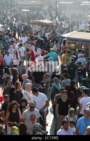 EMINONU, ISTANBUL, TÜRKEI; 26. JUNI 2018. Menschen drängen sich durch die Straße. Menschenmassen neben dem Bosporus, mit Moschee im Hintergrund, in Istanbul. Stockfoto