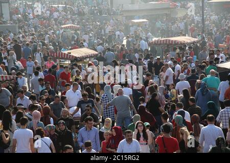 EMINONU, ISTANBUL, TÜRKEI; 26. JUNI 2018. Menschen drängen sich durch die Straße. Menschenmassen neben dem Bosporus, mit Moschee im Hintergrund, in Istanbul. Stockfoto