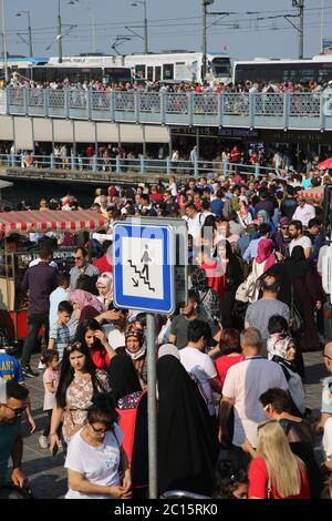 EMINONU, ISTANBUL, TÜRKEI; 26. JUNI 2018. Menschen drängen sich durch die Straße. Menschenmassen neben dem Bosporus, mit Moschee im Hintergrund, in Istanbul. Stockfoto