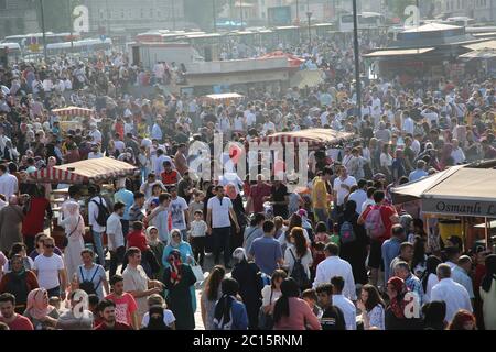 EMINONU, ISTANBUL, TÜRKEI; 26. JUNI 2018. Menschen drängen sich durch die Straße. Menschenmassen neben dem Bosporus, mit Moschee im Hintergrund, in Istanbul. Stockfoto