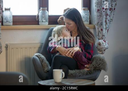 Mutter und Kind, sitzen in Schaukelstuhl, umarmt Stockfoto