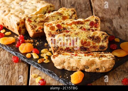 Traditioneller Obstkuchen mit getrockneten Aprikosen Beeren Rosinen Feigen Kirschen Closeup auf einem Schieferbrett auf dem Tisch. Horizontal Stockfoto