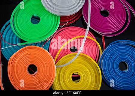 Flexible Leuchtstreifen Neon. Flexible LED-Band Neon Flex in verschiedenen Farben auf schwarzem Hintergrund. Stockfoto