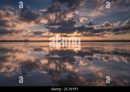 Ein atemberaubender Sonnenuntergang mit einem Himmel voller Wolken, der sich im Wasser eines Salzsees widerspiegelt, San Pedro del Pinatar, Murcia, Spanien Stockfoto