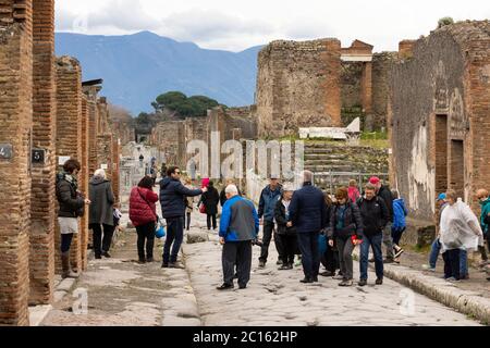 Touristen, die die Via delle Terme in der antiken römischen Stadt Pompeji, UNESCO-Weltkulturerbe, Campani, Italien, erkunden Stockfoto