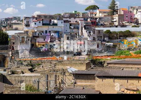 Luftaufnahme Blick hinunter in die alte Stadt, Gebäude und Ausgrabungen von Herculaneum mit modernen Ercolano Gebäuden über den Ruinen. Italien Stockfoto