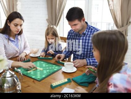 Glückliche junge Familie Flechten Brettspiel Stockfoto