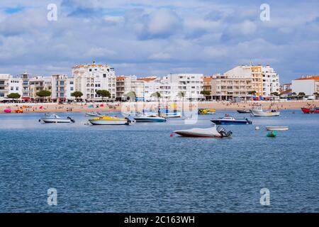 Boote in São Martinho do Porto Beach, Portugal - natürliche Mittelmeerküste mit goldenem Sand und ruhigem Meerwasser mit einzigartigen Felsformationen Stockfoto