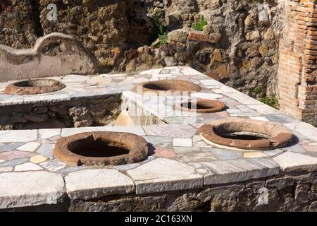 Roman Grande Taberna (Fast Food Outlet) mit Marmor-Theke und Keramik-Tonwaren-Behälter in der antiken Stadt Herculaneum, Italien Stockfoto