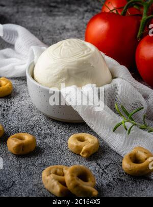 Frischer Mozzarella-Käse mit Rosmarin-Taralli und roten Tomaten. Stockfoto