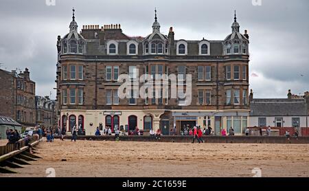 Portobello, Schottland, Großbritannien. 14. Juni 2020. Nach dem gestrigen Nebel den ganzen Tag, wurde es heute etwas heller und wärmer, aber immer noch dreich mit bewölktem Himmel, Temperatur von 16 Grad Celsius. Geschäftiges Meer mit allen Cafés und Pub geöffnet, im Bild: Drei weibliche Paddle-Boarder und eine Familie am Meer. Stockfoto