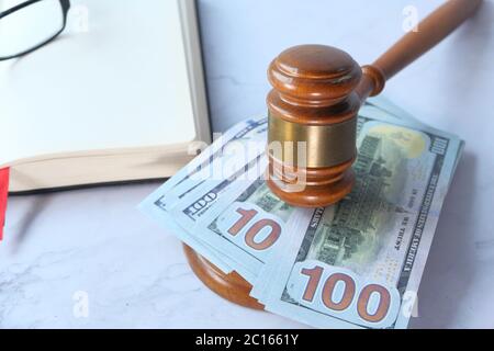 Nahaufnahme von Gavel, Bargeld und offenes Buch auf weißem Schreibtisch Stockfoto