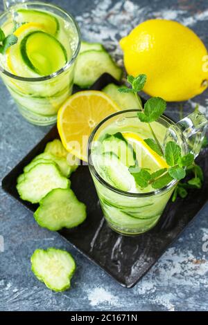 Frisches kaltes und erfrischendes Detox-Wasser mit Zitrone und Gurke auf einem Steintisch. Stockfoto
