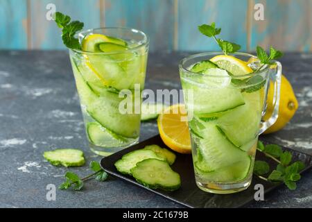 Frisches kaltes und erfrischendes Detox-Wasser mit Zitrone und Gurke auf einem Steintisch. Stockfoto
