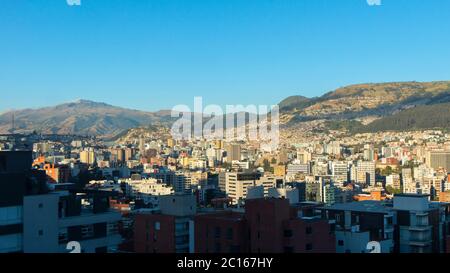 Panoramablick auf den zentralen Bereich der Stadt Quito mit dem Atacazo Berg im Hintergrund an einem sonnigen Morgen Stockfoto