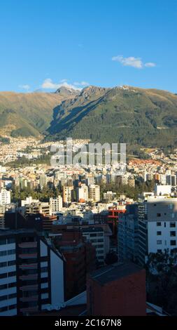 Panoramablick auf den zentralen Bereich der Stadt Quito mit dem Rucu Pichincha im Hintergrund an einem sonnigen Morgen Stockfoto