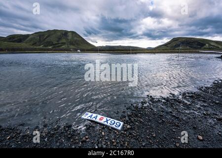 LANDMANNALAUGAR, ISLAND - 6. AUGUST 2020: Verlorenes Nummernschild vor einer furt durch einen Fluss Stockfoto