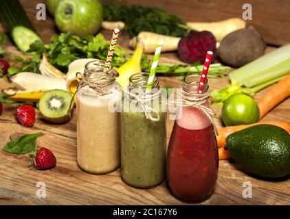 Sortiment von Obst- und Gemüsesorten in Glasflaschen mit Trinkhalmen Stockfoto