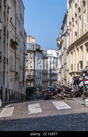 Paris, Frankreich, 26. März 2017: Blick auf die enge gepflasterte Straße zwischen traditionellen pariser Gebäuden in Paris, Frankreich. Stockfoto