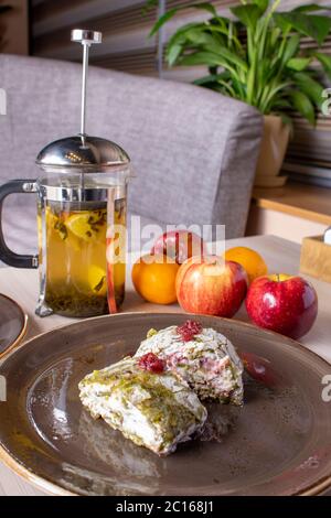 Eistüte mit Minze und Zitrone mit Äpfeln, keine Zuckerkuchen auf dem Teller. Blumenhintergrund Stockfoto