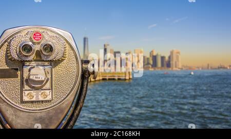 Nahaufnahme eines Fernglases mit Turmschauern und verschwommener Skyline von New York City Stockfoto