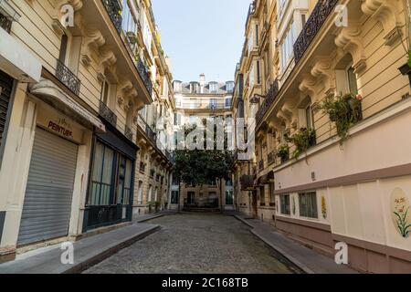 Paris, Frankreich, 26. März 2017: Blick auf die enge gepflasterte Straße zwischen traditionellen pariser Gebäuden in Paris, Frankreich. Stockfoto