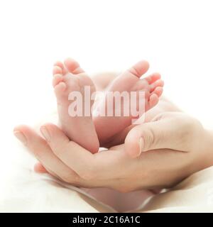 Die Hand der Mutter hält die Beine Stockfoto