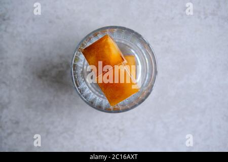 Kaffee Eiswürfel in Glas, Gießen Kokosmilch. Vorbereitung erfrischenden Kaffee trinken. Stockfoto