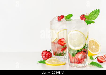 Erfrischender Sommercocktail mit Erdbeeren, Minze, Zitrone und Limonade auf weißem Hintergrund. Speicherplatz kopieren Stockfoto