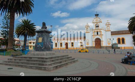 Quito, Pichincha / Ecuador - Februar 17 2019: Menschen sitzen im Zentralpark mit der Quiroga Kirche im Hintergrund. Es ist eine Pfarrei der Dose Stockfoto