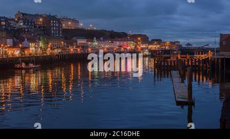 Fluss Esk fließt durch Whitby Hafen am Abend zeigt Reflexionen aus der Stadt Stockfoto