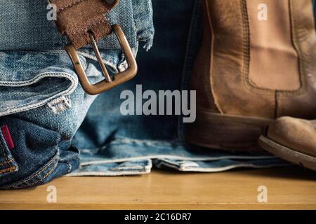 Gürtel und Jeans auf Holz. Stockfoto