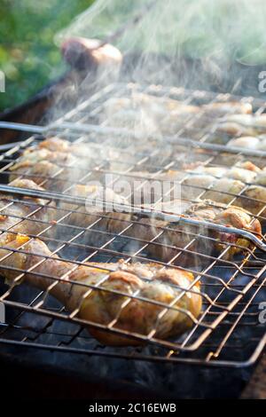 Grill geräucherte Hähnchenbeine Vorbereitung auf einem Metallgrill im Freien, selektive Fokus Stockfoto