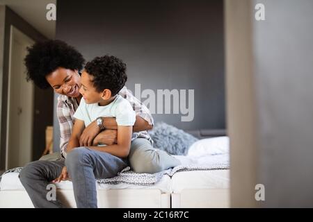 Glückliche Mutter spielen, Spaß haben, umarmen, mit ihrem Sohn zu Hause Stockfoto