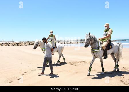 Sale, Marokko. Juni 2020. Berittene Soldaten, die auf einem Strand patrouillieren, begleiten einen Mann, der am 14. Juni 2020 in Sale, Marokko, abreisen soll. Marokko hat am Sonntag 101 neue COVID-19-Infektionen angekündigt, was die Gesamtzahl der bestätigten Fälle im nordafrikanischen Land auf 8,793 erhöht. Quelle: Chadi/Xinhua/Alamy Live News Stockfoto