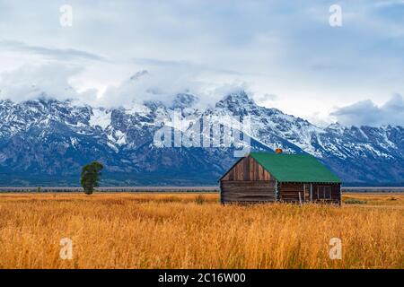 Grand Teton Range Peaks im ersten Schnee und Nebel im Herbst mit einem Gebäude der T. A. Molton Scheune im Grand Teton National Park, Wyoming, USA. Stockfoto