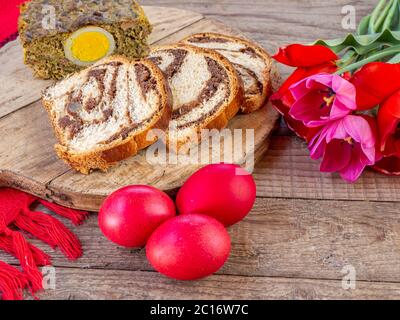 Lammkutteln Fleischkuchen, Biskuitkuchen und bunte ostereier auf dem Tisch Stockfoto