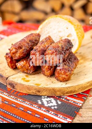 Hautenlose Fleischbrötchen Wurst oder Mici traditionelle balkan rumänische Ottomanen Küche Delikatesse serviert auf einem Holzteller in einem rustikalen Dekor Stockfoto