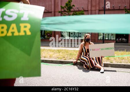 14. Juni 2020, Berlin, Berlin, Deutschland: Eine Frau mit einem Schild ist zu sehen, während mehrere tausend Menschen, verschiedene Allianzen, linke Parteien und NGOs an einer Demonstration mit dem Titel "Unteilbar" teilnehmen, um eine Menschenkette aufzubauen, um für eine antirassistische, soziale und klimafreundlichen Gesellschaft zu protestieren. Die Teilnehmer stehen auf einer langen Strecke von neun Kilometern, auf der die meisten Teilnehmer die erforderliche Distanz von 3 Metern halten und aufgrund der anhaltenden weltweiten Covid-19-Pandemie Gesichtsmasken tragen. Gemeinsam bilden sie das sogenannte "Band der Solidarität" (Bildquelle: © Jan Scheunert/ZUMA Wire) Stockfoto