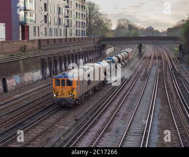 GB Railfreight Klasse 73 Dual-Mode-Lokomotive vorbei Clapham Junction mit einem Network Rail Railhead Behandlung Zug Jetting Herbst verlässt die Linie Stockfoto